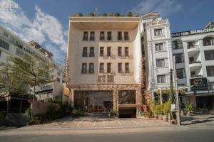 a tall building in the middle of two buildings at Le Récit Boutique Hôtel de Dalat in Da Lat