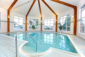 a swimming pool in a house with windows at Sonnenhotel Feldberg am See mit Schwimmbad, Sauna und Dampfbad in Feldberg