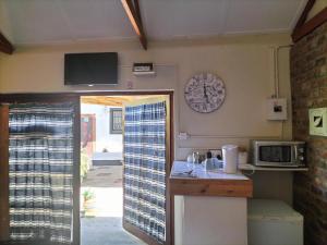 a kitchen with a counter and a tv on the wall at Garden Cottage Guest House in De Aar