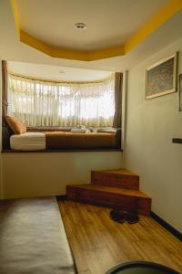 um pequeno quarto com uma cama e uma janela em Apinya Resort Bangsarey em Ban Tao Than