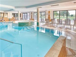 - une grande piscine avec des chaises dans un bâtiment dans l'établissement Wonderful La Villa du Lac - One Bedroom, 4 people, à Divonne-les-Bains