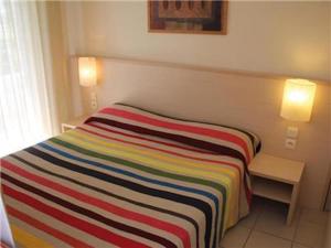 a striped blanket on a bed in a room at Wonderful La Villa du Lac - One Bedroom, 4 people in Divonne-les-Bains