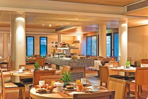 un restaurant avec des tables et des chaises et une cuisine dans l'établissement Wonderful La Villa du Lac - One Bedroom, 4 people, à Divonne-les-Bains