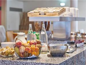 a counter with a bowl of apples and bottles on it at Wonderful La Villa du Lac - One Bedroom, 4 people in Divonne-les-Bains