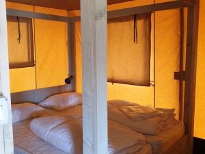 2 literas en una habitación con paredes amarillas en Safaritent Ranger Lodge, en Kesteren