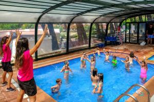 a group of children playing in a swimming pool at Ciudad De Vacaciones Cala Montjoi in Roses