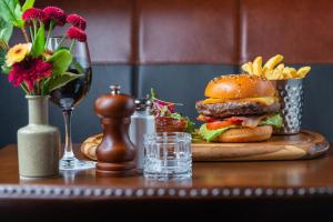 un hamburger e patatine fritte su un tavolo con un bicchiere di vino di Manor West Hotel & Leisure Club a Tralee