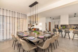 a dining room with a long table and chairs at Villa Borealis in Raša