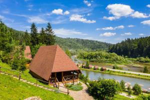 ein Gebäude mit einem Dach neben einem Fluss in der Unterkunft Osonnya Karpaty 4* in Schidnyzja