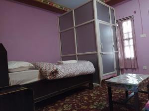 1 dormitorio con cama y estante para libros en Hotel Sauraha Gaida House, en Chitwan