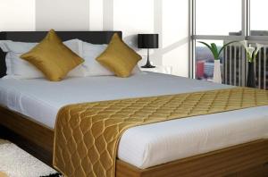 a bedroom with a large bed with yellow pillows at City Plaza in Panchkula