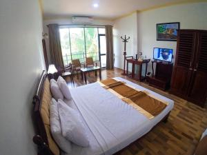 um quarto com uma cama grande num quarto em Centauria City Hotel em Embilipitiya