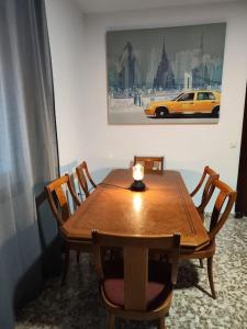 a wooden table with chairs and a candle on top at Mar Carihuela Apartamento in Torremolinos