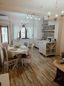 kuchnia i jadalnia ze stołem i krzesłami w obiekcie PORTO SOFIA w mieście Kumanowo