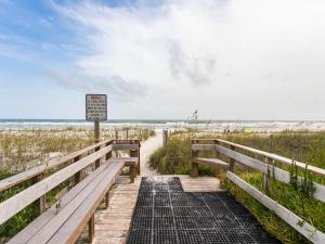 a wooden boardwalk to the beach with a sign at Aqua Villa #101 in Fort Walton Beach