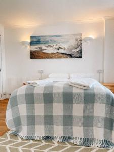 een slaapkamer met een bed met een geruite deken bij Reef Lodge in Newquay
