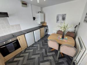 una piccola cucina con tavolo e sedie in legno di Dainville Lodge a Skegness