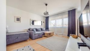 a living room with a couch and a table at Apartamenty Sun & Snow Legionów in Gdynia