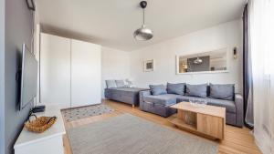 a living room with a blue couch and a table at Apartamenty Sun & Snow Legionów in Gdynia