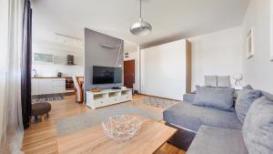a living room with a couch and a tv at Apartamenty Sun & Snow Legionów in Gdynia