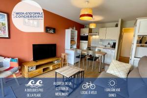 kuchnia oraz salon z telewizorem i salonem w obiekcie Appartement MerliDunes Proche de la plage w mieście Merlimont