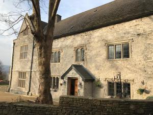 a large stone building with a tree in front of it at Y Fan in Caerphilly