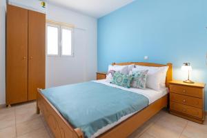 a bedroom with a bed with a blue wall at Artoria Apartment 2 First Floor in Haraki