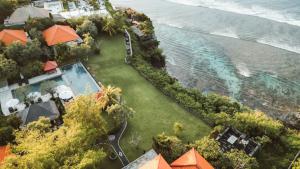 een luchtzicht op een resort met een zwembad en de oceaan bij Uluwatu Cottages in Uluwatu