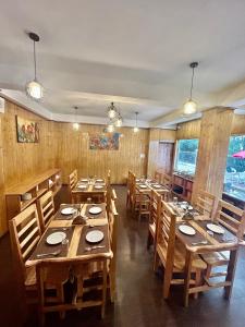 a dining room with wooden tables and wooden chairs at Amaira Resort & Farms - Mirik, West Bengal in Mirik