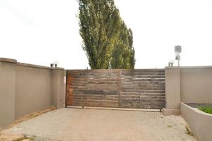 a fence with a wooden gate and a tree at Bethlehem Sundowners Guesthouse in Bethlehem