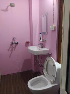a pink bathroom with a toilet and a sink at Hotel Sauraha Gaida House in Chitwan