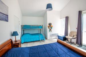 a bedroom with a blue bed and a chair at Gîte Libellule au coeur de la nature in Moncoutant