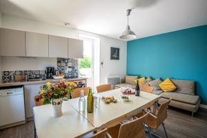 a kitchen and living room with a table with flowers on it at Gîte Martin pêcheur au coeur de la nature in Moncoutant