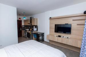 um quarto com uma cama e uma televisão de ecrã plano em OASIS PARK RESIDENCE em East Legon