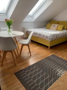 a bedroom with a bed and a table and a chair at Apartament Kendal in Dźwirzyno