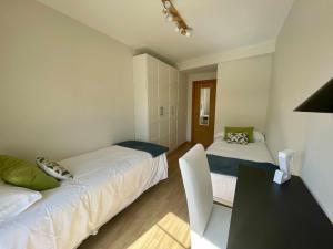 a bedroom with two beds and a table with a desk at Zabella Mercado central in Zaragoza