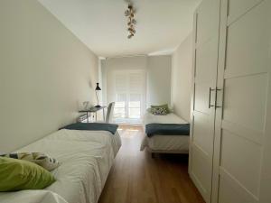 a small bedroom with two beds and a window at Zabella Mercado central in Zaragoza +4 photos