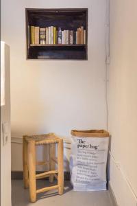 un estante de libros y un taburete con un letrero. en Secret Garden House en Lisboa