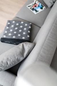 Um sofá cinzento com uma almofada de bandeira americana. em Strandloft Eins Norderney em Norderney