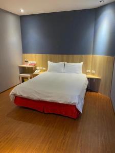 台南的住宿－太子大飯店，一间卧室设有一张大床和蓝色的墙壁