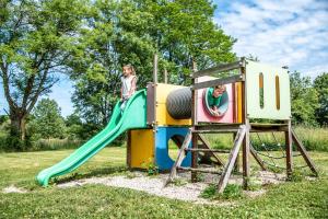 two children playing on a slide at a playground at Gîte Martin pêcheur au coeur de la nature in Moncoutant