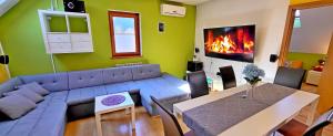 uma sala de estar com um sofá, uma mesa e uma lareira em Simonai Apartment em Bovec