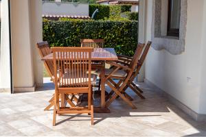a wooden table and chairs on a patio at Villa Dalia Punta Molara San Teodoro in San Teodoro