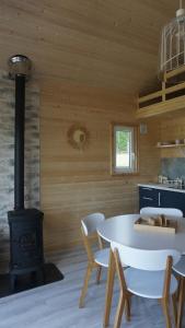 a kitchen with a stove and a table and chairs at Między Lasem a Wodą in Nowe Worowo