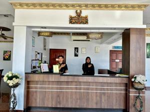 two women standing at the reception desk of a waiting room at Langkawi Baron Hotel in Kuah