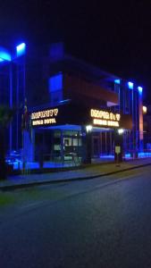 budynek z niebieskimi światłami na ulicy w nocy w obiekcie Infinity Hotel w mieście Kemer