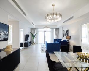 a living room with a glass table and blue chairs at Luxury 2 bedroom apartment in Madinat Jumeirah Living in Dubai