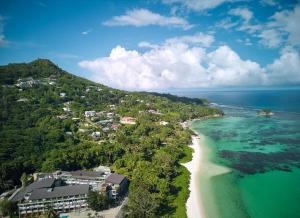 laïla, Seychelles, a Marriott Tribute Portfolio Resort في ماهي: اطلالة جوية على شاطئ به بيوت ومحيط