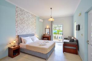 a bedroom with a bed and a couch and a window at Poseidon Apartments in Kato Daratso +43 photos