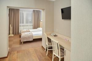 una camera con letto e scrivania di Hotel Korona a Mostiska